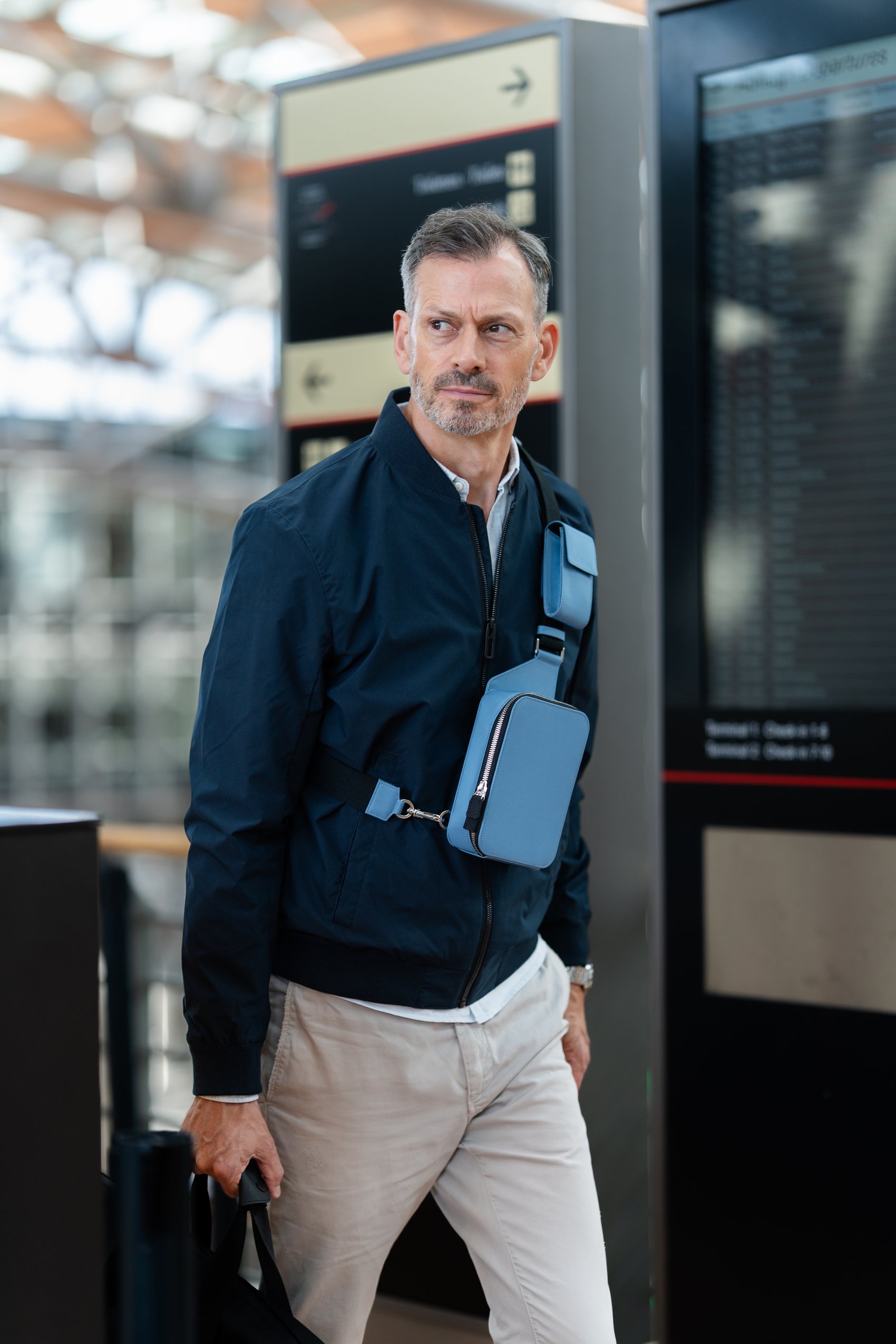 Man at an airport wearing The Verso across his chest.